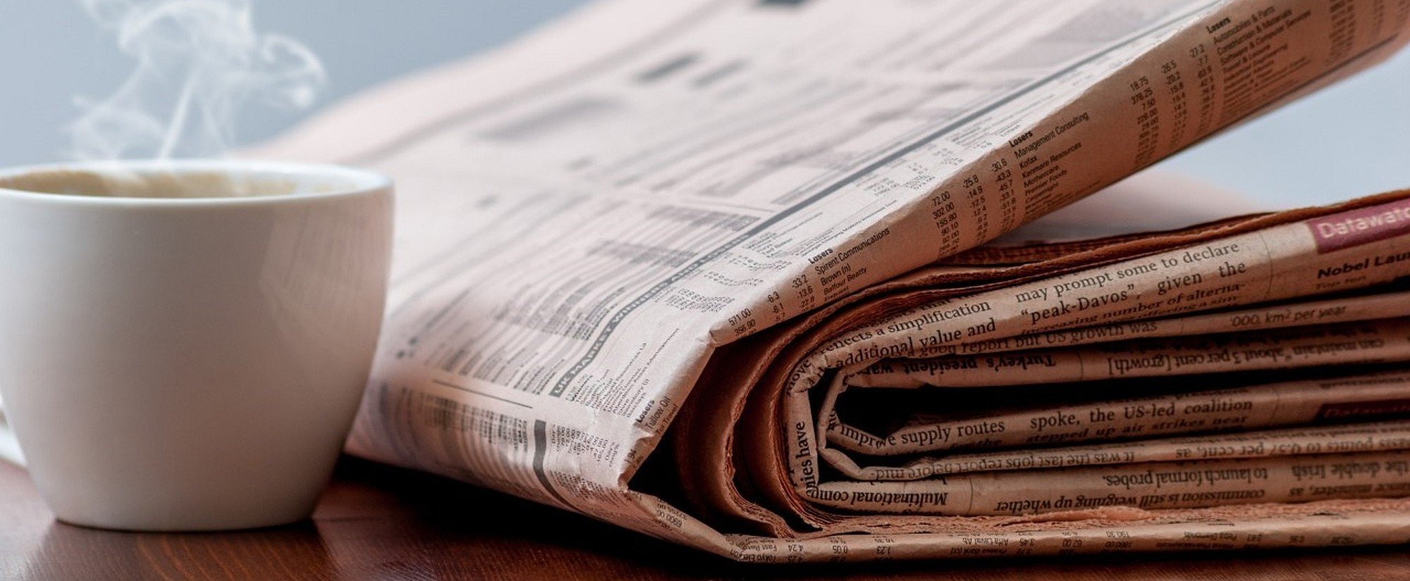News page heading image showing a newspaper and a coffee